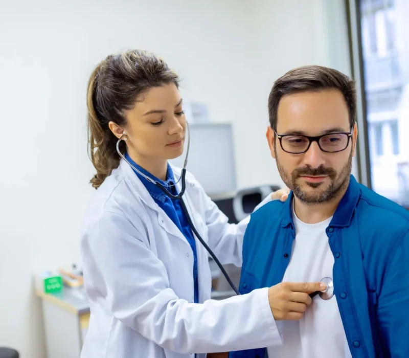 Una-joven-doctora-escucha-el-pecho-masculino